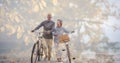 Composition of senior couple walking with bicycles on beach and autumn foliage Royalty Free Stock Photo