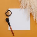 Composition of setting powder and brush next to cereal bouquet over orange