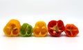 Composition of several halves of ripe sweet pepper of different colors on a light background.