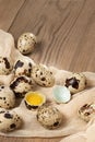 Composition of several quail eggs on decorative fabric on a wooden table close-up, copy space, virtical banner, flatlay