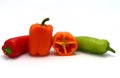 Composition of several sweet peppers and their halves of different colors on a light background.