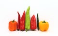 Composition of several types of sweet pepper of different shapes, colors and sizes on a light background.