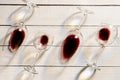 Composition with several used wine glasses with leftover liquid over wooden background. Top view with copy space