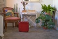 Composition of sideboard, vintage red suitcase, mirror, natural plants and retro armchair. Retro and antique concept Royalty Free Stock Photo