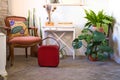 composition of sideboard, vintage red suitcase, mirror, natural plants and retro armchair. Retro and antique concept Royalty Free Stock Photo