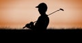Composition of silhouette of golf player over orange sky with copy space