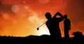 Composition of silhouette of golf players over orange sky with copy space