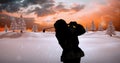 Composition of silhouette of santa claus playing golf over winter landscape