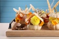 Composition with small pumpkins, beautiful flowers and spikelets on light wooden table, closeup Royalty Free Stock Photo