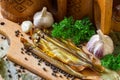 Composition with smoked fish capelin with spices and kitchen utensils. Royalty Free Stock Photo