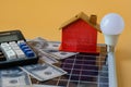 Composition with solar panel, led lamp, money and model house on texture. Royalty Free Stock Photo
