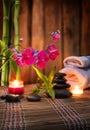 Composition spa massage - bamboo - orchid, towels, candles and black stones Royalty Free Stock Photo