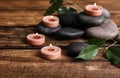 Composition of spa stones, green leaves and burning candles Royalty Free Stock Photo