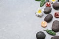 Composition with spa stones and lit candles on grey marble background Royalty Free Stock Photo