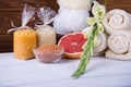 Composition of spa treatment on white wooden background with grapefruit, gladiolus, towels, bath bomb and candles. With copy spac Royalty Free Stock Photo