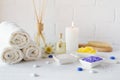 Composition of spa wellness products on white background. with towel,white lily, sea salt, bath oil, sugar body scrub Royalty Free Stock Photo