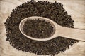 Composition of a spoon with black pepper.