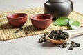 Composition with spoon of Tie Guan Yin Oolong tea and brewed beverage Royalty Free Stock Photo