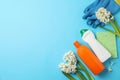 Composition with spring flowers and cleaning supplies on blue background, flat lay. Space for text