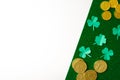 The composition of the St. Patrick`s day. Leaves of paper clover and gold coins on a green shiny and white background Royalty Free Stock Photo