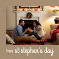 Composition of st stephen\'s day text and biracial couple at christmas by fireplace