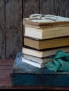 The composition of a stack of old books and glasses on a wooden background. Vintage photo. Royalty Free Stock Photo