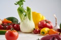 Still life of a bunch fresh different seasonal green vegetables avocado, fennel, garlic, onion, tomato, red yellow pepper. Royalty Free Stock Photo