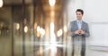 Composition of successful caucasian businessman smiling over blurred office corridor background