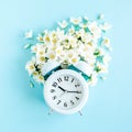 Composition-Summer time from Jasmine flower and clock, alarm on blue background. Flat lay, top view Royalty Free Stock Photo