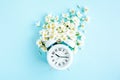Composition-Summer time from Jasmine flower and clock, alarm on blue background. Flat lay, top view Royalty Free Stock Photo