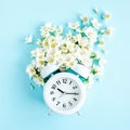 Composition-Summer time from Jasmine flower and clock, alarm on blue background. Flat lay, top view Royalty Free Stock Photo