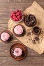 Composition with sweet cupcakes, chocolate and raspberry on wooden table