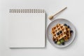 composition tasty breakfast waffles with empty notebook. High quality photo