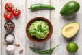 Composition with tasty guacamole, spices and vegetables on wooden background Royalty Free Stock Photo