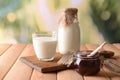 Composition with tasty milk, jam and cookies on wooden table Royalty Free Stock Photo