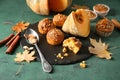 Composition with tasty muffins, cut pumpkin and cinnamon on color table Royalty Free Stock Photo