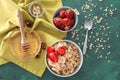 Composition with tasty oatmeal, berries and fruit on green table