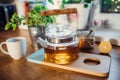 Composition of tea in a teapot, sugar, lemon and cup on wooden table.