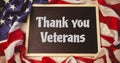 Composition of text thank you veterans in white on chalkboard on crumpled american flag Royalty Free Stock Photo