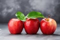 Three apples with leaves on table, dark background Royalty Free Stock Photo