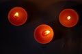 Composition of three candles on dark luxury night background. Black table, top view. Candles Burning at Night.