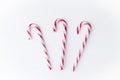 Composition of three Christmas candy canes on a white wooden background. Place for text