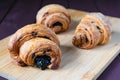 composition, three croissants with chocolate filling on a wooden table Royalty Free Stock Photo