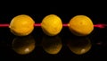 Composition with three lemons on a black background