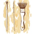 Three painting brushes on a light brown background.