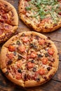 Composition of three various kinds pizzas on wooden table