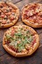 Composition of three various kinds pizzas on wooden table