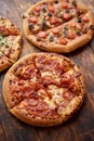 Composition of three various kinds pizzas on wooden table