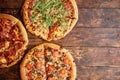 Composition of three various kinds pizzas on wooden table