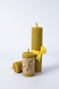 Composition of three wax candles on a white background. natural beeswax. handmade candles